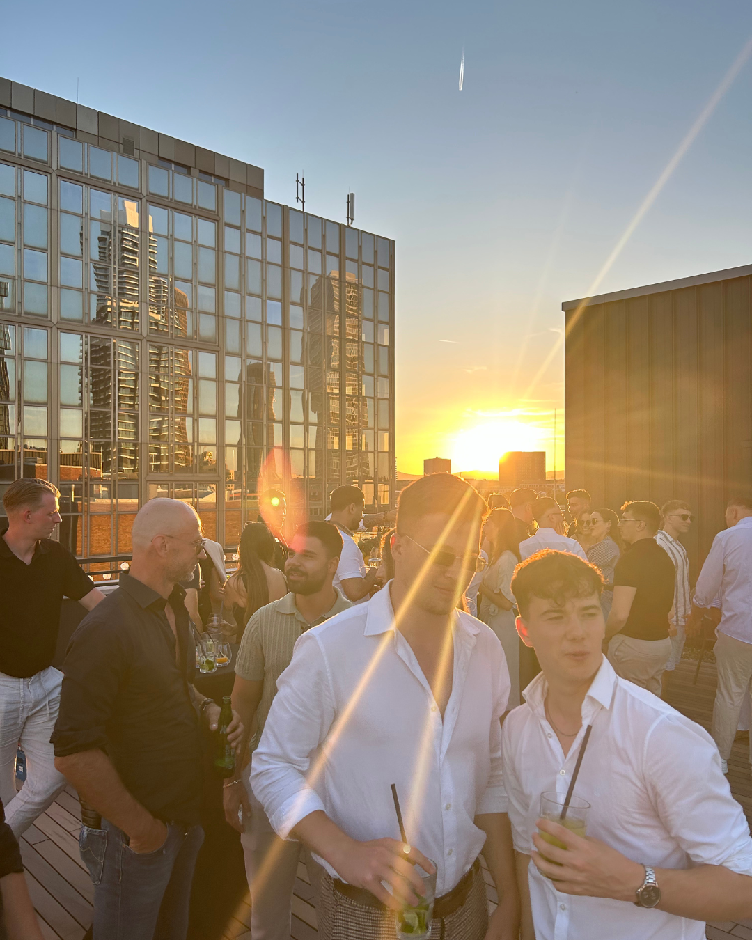 Team bei Sonnenuntergang auf der Dachterrasse